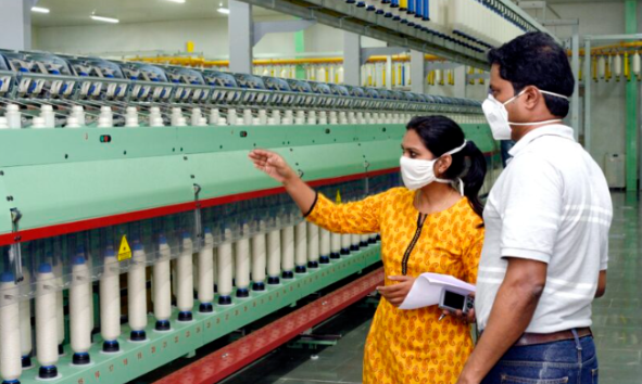 Femme et homme inspectant une machine dans une usine